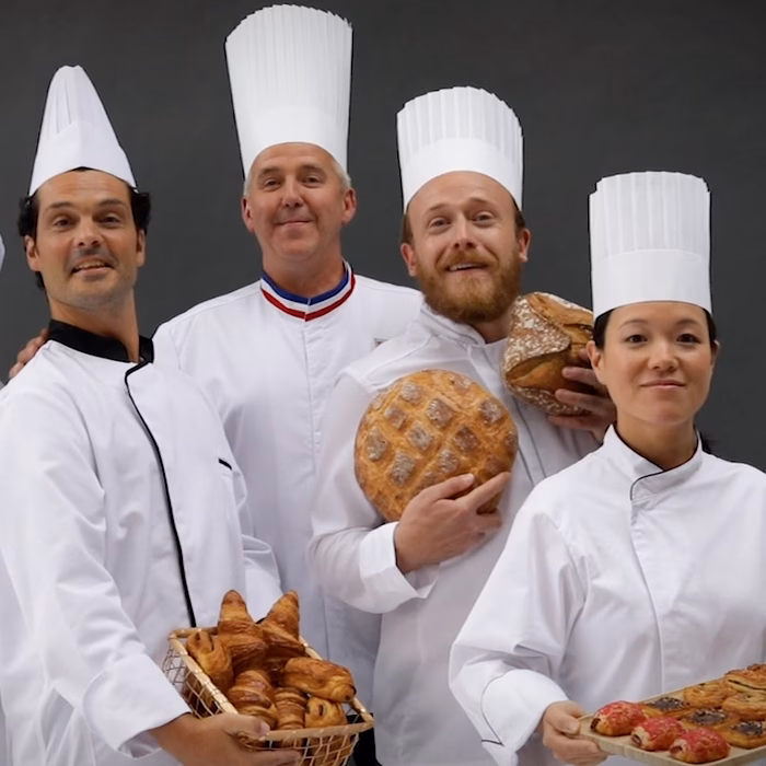 Cinq chefs en toque portant pains et viennoiseries, film web Bridor réalisé par Sonacom