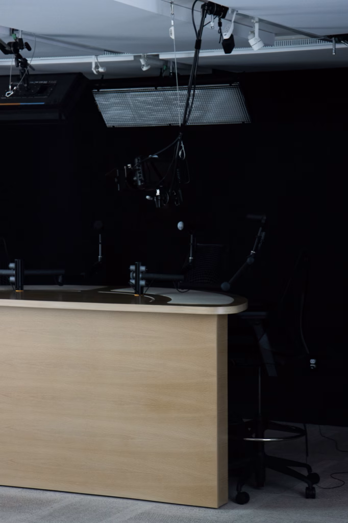 Cabine d'enregistrement sobre avec bureau et micro sur pied