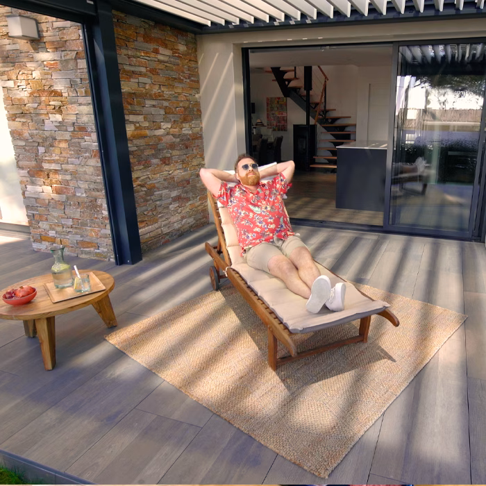 Femme allongée sur un transat sous une pergola bioclimatique, film publicitaire Gustave Rideau par Sonacom