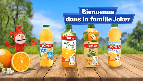 Bouteilles de jus Joker et leur mascotte sur une table en bois, film corporate réalisé par Sonacom