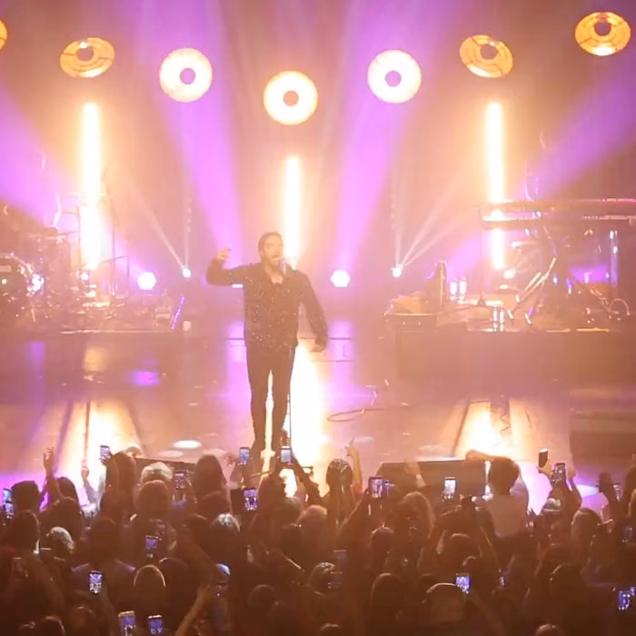 Scène de concert et public sous les projecteurs violets, film promotionnel La Poste Mobile par Sonacom