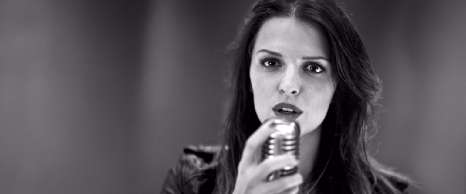 Portrait noir et blanc de Ludivine Aubourg, comédienne voix off Sonacom, le micro vintage tout près des lèvres