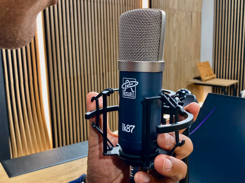 Micro à condensateur Roswell Mini K87 tenu à la main dans le studio