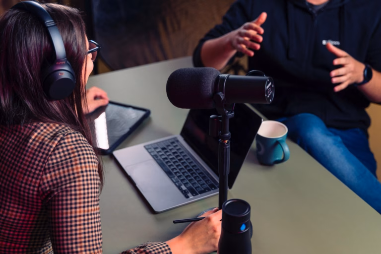 Deux personnes discutent autour d'une table lors de l'enregistrement d'un podcast