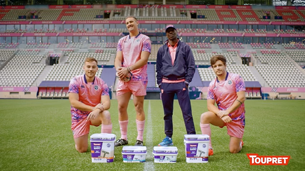 Sportifs en rose posant avec des pots Toupret dans un stade, websérie réalisée par Sonacom