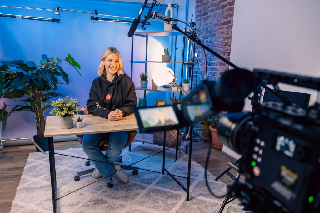 Tournage d'un podcast vidéo en studio bleu, caméra au premier plan